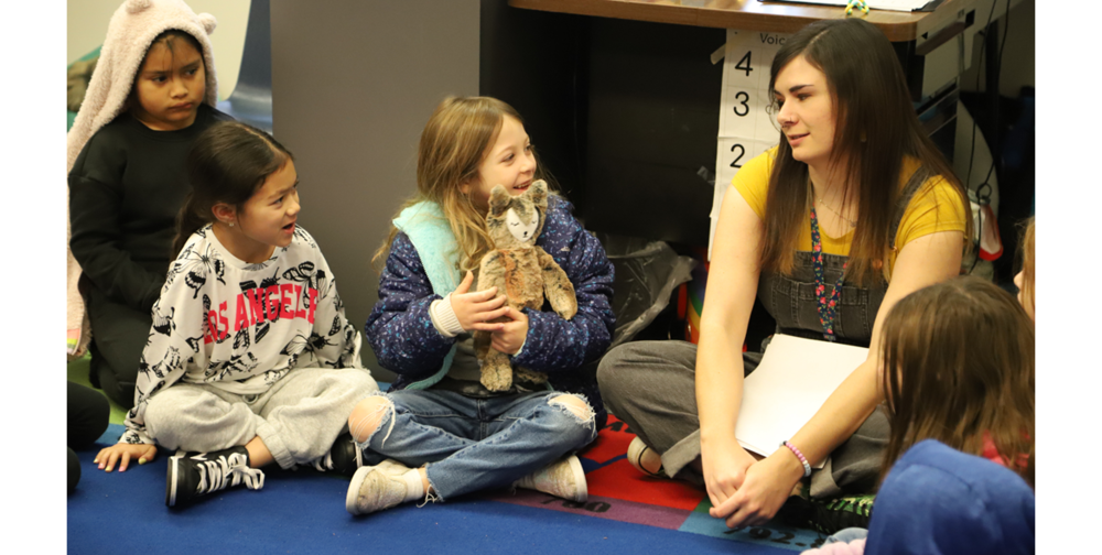 Students pass around a donated stuffed fox during story time