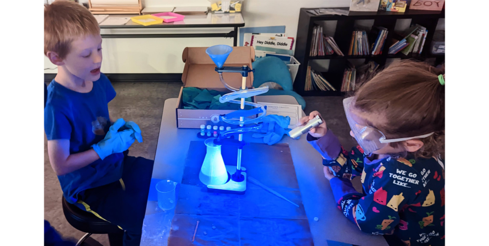 K-3 students (L to R) Ammon Caine and Ele Kuhn perform an experiment with Glow Lab at Wisdom Ridge Academy