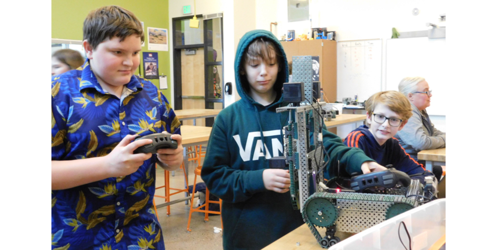 Devereaux Lewis, Nathan Fraker, and Calvin Selim pick up remote controls as they prepare to run a test