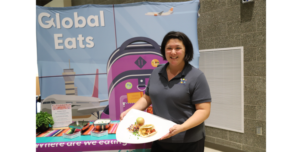 Chartwells employee Amber Vesely holds up a plate of fish tacos