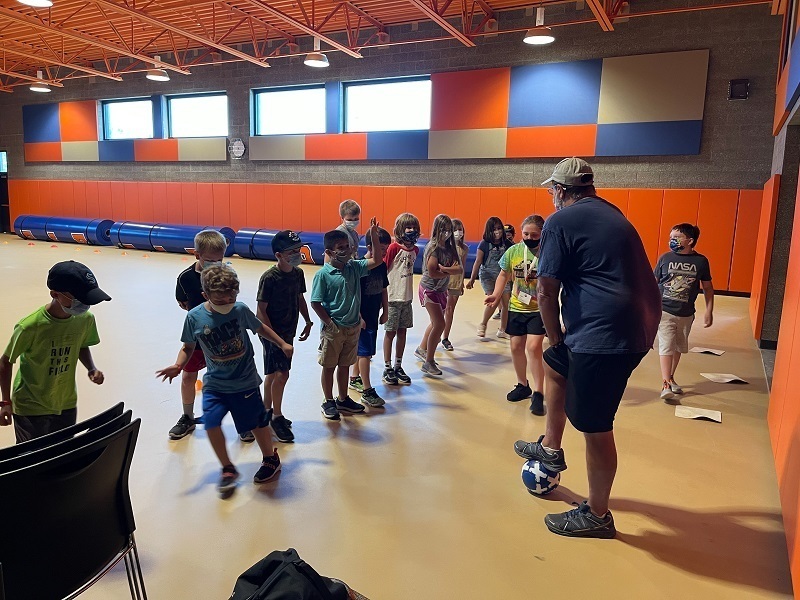 Soccer coach Jeff Brink provides a quick soccer lesson as part of a Fun Friday activity